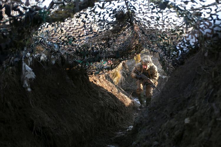 En ukrainsk soldat patruljerer i en skyttegrav ved frontlinjen i den østlige Donbass-region. Så godt som hver dag kræver krigen mellem Ukraine og russisk støttede separatister sine dødsofre. Foto: Anatolii Stepanov/Ritzau Scanpix