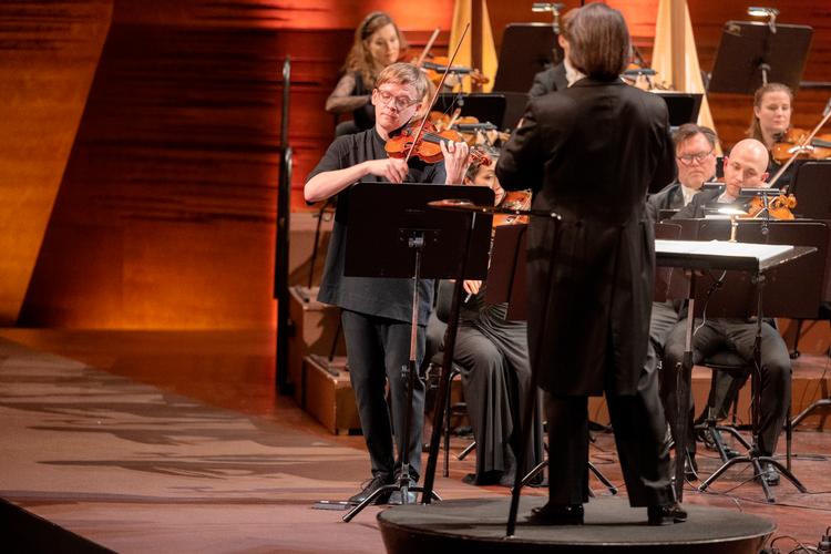 Den finske violinist Pekka Kuusisto spillede folkemusik. Både som den nulevende komponist Thomas Adès forestiller sig den, og i finsk aftapning. Med ryggen til: Dirigent Ion Marin. Foto: Tilde Døssing Tornbjerg