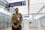 En politibetjent fra Saudi-Arabien venter på kinesiske pilgrimme med teksten 'jeg taler kinesisk' på sit label. Arkivfoto. Foto: Amr Nabil/Ritzau Scanpix