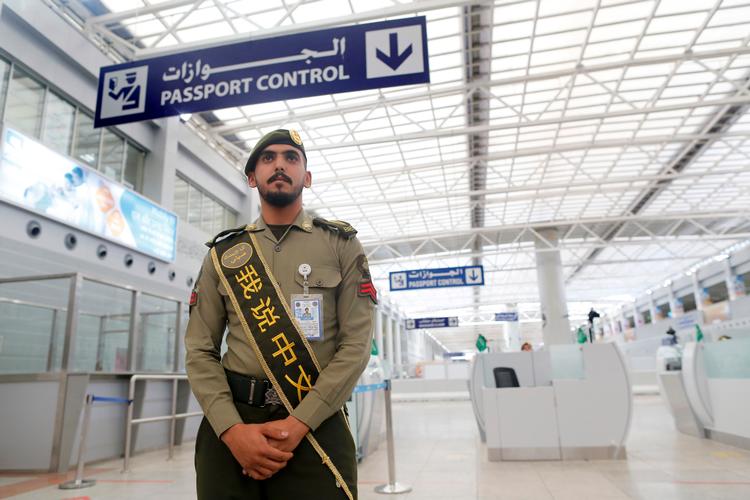 En politibetjent fra Saudi-Arabien venter på kinesiske pilgrimme med teksten 'jeg taler kinesisk' på sit label. Arkivfoto. Foto: Amr Nabil/Ritzau Scanpix