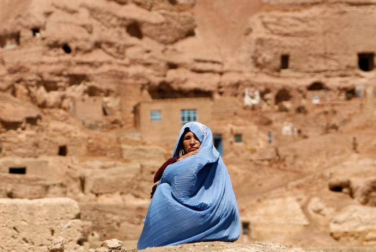 En afghansk kvinde sidder foran sit hjem nær den gigantiske buddha-statue i Bamiyan-provinsen.  Foto: Omar Sobhani/Ritzau Scanpix