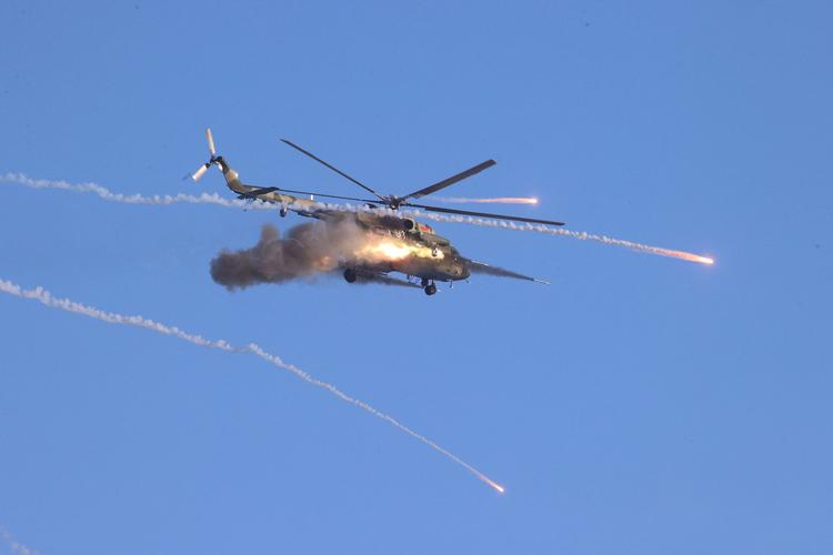 En helikopter affyrer missiler under en øvelse i dag mellem hviderussiske og russiske styrker i Hviderusland.  Foto: Belta/Ritzau Scanpix