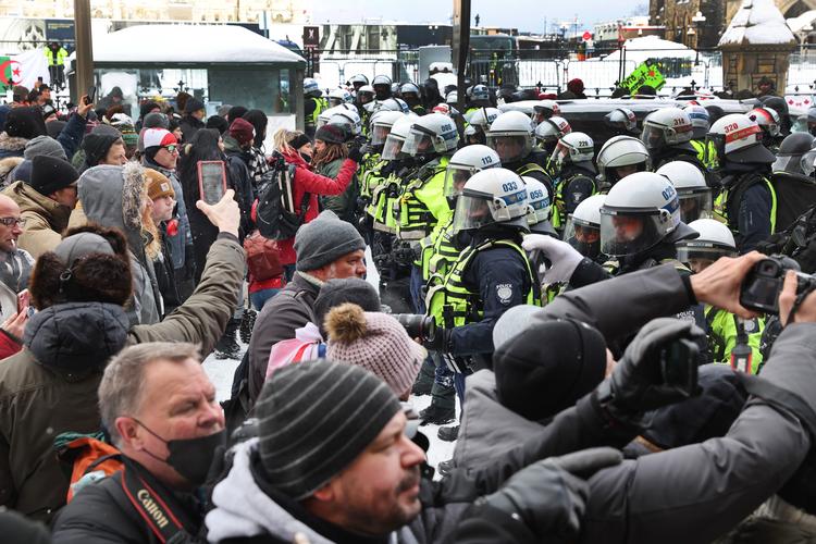 OTTAWA, ONTARIO - FEBRUARY 19: Police face off with demonstrators participating in a protest organized by truck drivers opposing vaccine mandates on February 19, 2022 in Ottawa, Ontario, Canada The drivers have used vehicles to form a blockade that has blocked several streets near Parliament Hill. Prime Minister Justin Trudeau has invoked the Emergencies Act in an attempt to try to put an end to the demonstration that has nearly paralyzed a portion of downtown Ottawa for 22 days. Scott Olson/Getty Images/AFP == FOR NEWSPAPERS, INTERNET, TELCOS &amp; TELEVISION USE ONLY == Foto: Scott Olson/Ritzau Scanpix