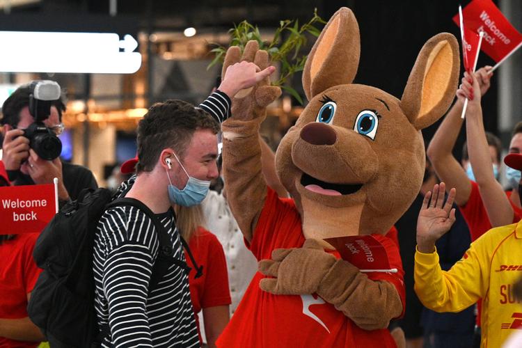 En maskot byder de første turister i to år i Australien velkommen i lufthavnen i Sydney. Foto: Saeed Khan/Ritzau Scanpix