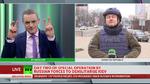 På mange måder minder RT UK om tilsvarende nyhedskanaler som TV 2 News. Det er værtsbåret tv, hvor der stilles om til såvel eksperter  som journalister i marken. Her er det fredag middag dansk tid og en journalist er igennem fra Donetsk.  Bemærk at  kanalen ikke kalder det en krig, men bruger ordene ’Specialoperationen til at demilitarisere Kiev’.    Foto: Screendump fra RT UK