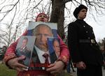 En kvinde omfavner skilte med præsident Vladimir Putin, forsvarsminister Sergei Shoigu og udenrigsminister Sergei Lavrov i byen Sevastopol i den russiskannekterede halvø Krim. Anledningen er festdagen for forsvar af fædrelandet den 23. februar. Både Putin og Lavrov kan være omfattet af immunitet i Den Internationale Straffedomstol ICC, mener en ekspert. Foto: Alexey Pavlishak/Ritzau Scanpix