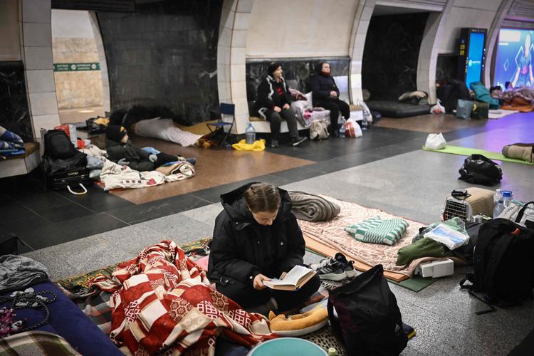 En ukrainsk kvinde har søgt tilflugt mod bomber i en metrostation i Kyiv og får tiden til at gå ved at læse. »Litteratur er det modsatte af krig«, lyder det da også fra den russiske forfatter Mikhail Sjiskin, der er bare én ud af utallige forfattere fra det russisktalende område, der på trods af risiko for straf har kritiseret Ruslands invasion af Ukraine.  Foto: Aris Messinis/Ritzau Scanpix