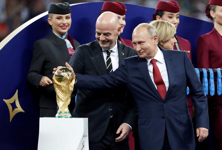 I 2018 var Vladimir Putin som vært for slutrunden tæt på VM-trofæet sammen med Fifa-præsident Gianni Infantino, men nu er Rusland udelukket fra at kunne kvalificere sig til den næste slutrunde. Foto: Damir Sagolj/Ritzau Scanpix
