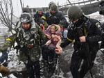 Over to millioner ukrainere er flygtet ud af landet. Her hjælpes en ældre kvinde ud af Kyiv-forstaden Irpin.  Foto: Sergei Supinsky/Ritzau Scanpix