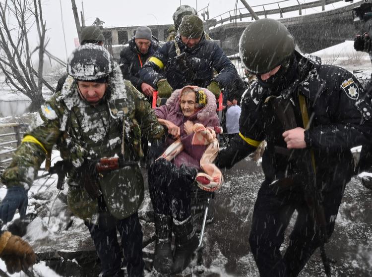 Over to millioner ukrainere er flygtet ud af landet. Her hjælpes en ældre kvinde ud af Kyiv-forstaden Irpin.  Foto: Sergei Supinsky/Ritzau Scanpix
