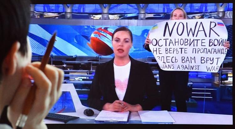 Den russiske tv-redaktør Marina Ovsyannikova holder antikkrigs-skilt op i direkte udsendelse på russisk stats-tv. Foto. AFP 