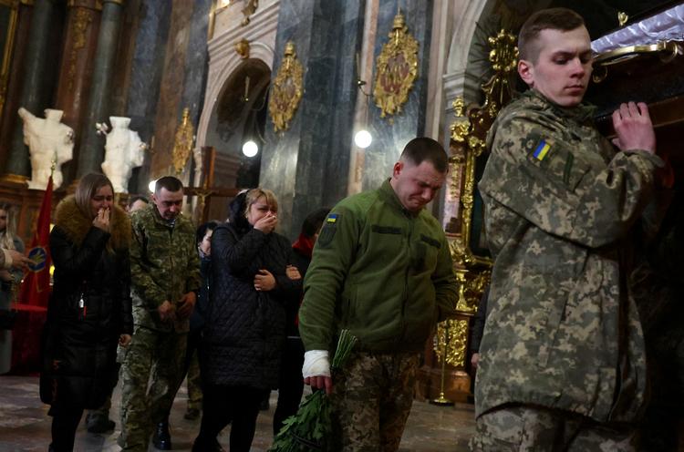 Pårørende og soldaterkammerater deltager i begravelsen af den ukrainske soldat Eduard Niezhenets, der blev dræbt i et russisk raketangreb. Billedet er fra Kyiv i går.  Foto: Kai Pfaffenbach/Ritzau Scanpix