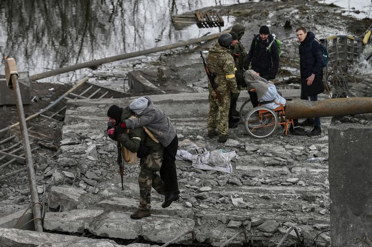 Billedet fra 7. marts viser ukrainere i den bombede by Irpin vest for Kyiv.  Foto: Aris Messinis/Ritzau Scanpix