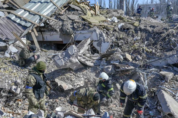 Ukrainske soldater og redningsfolk leder efter overlevende i ruinerne af en flådebase i Mykolajiv, der blev ramt af et russisk missilangreb tidligt fredag. Med formentlig mindst 40 døde var angrebet et af de blodigste mod Ukraines militær siden krigens start.  Foto: Bulent Kilic/Ritzau Scanpix