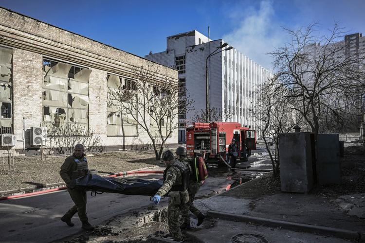 Ukrainere bærer en dræbt væk efter et russisk luftbombardement i Kyiv. Foto: Aris Messinis/Ritzau Scanpix