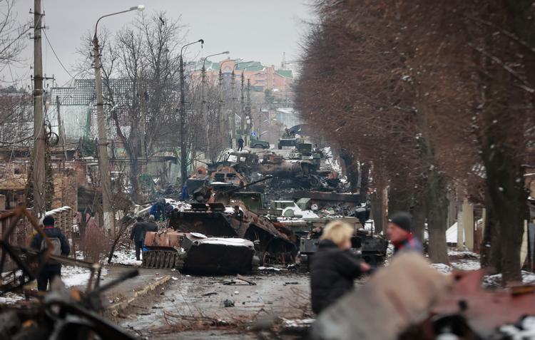 Lokale besigtiger ødelæggelserne ved byen Bucha, tæt på hovedstaden Kyiv, 1. marts. Foto: Serhii Nuzhnenko/Ritzau Scanpix