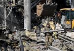  Mens Natos topledere mødtes i Bruxelles, fortsatte den russiske bombe- og missilregn over Ukraine. Her fjerner en ukrainsk soldat fragmenter af en tilsyneladende ueksploderet russisk raket fra en ruinhob i hovedstaden, Kyiv.
  Foto: Sergei Supinsky/Ritzau Scanpix