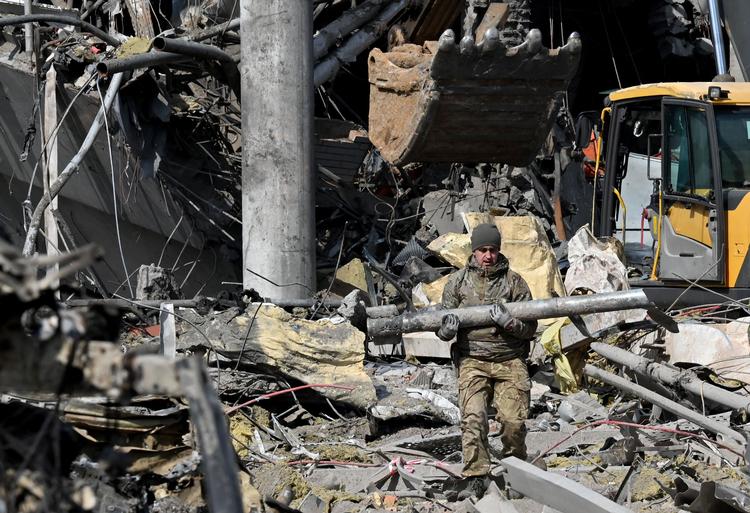  Mens Natos topledere mødtes i Bruxelles, fortsatte den russiske bombe- og missilregn over Ukraine. Her fjerner en ukrainsk soldat fragmenter af en tilsyneladende ueksploderet russisk raket fra en ruinhob i hovedstaden, Kyiv.
  Foto: Sergei Supinsky/Ritzau Scanpix