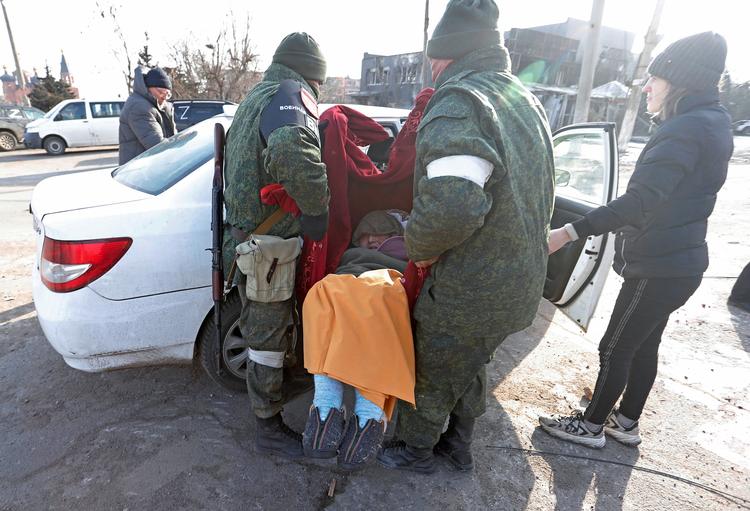 En ældre kvinde bæres ind i en bil af pro-russiske tropper ved den belejrede ukrainske havneby Mariupol. Foto: Alexander Ermochenko/Ritzau Scanpix