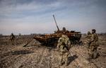 Ukrainske soldater samles om en udbrændt russisk kampvogn uden for Kyiv torsdag. Ifølge en amerikansk tænketank er Rusland de seneste dage trængt tilbage i området ved hovedstaden.  Foto: Ronaldo Schemidt/Ritzau Scanpix
