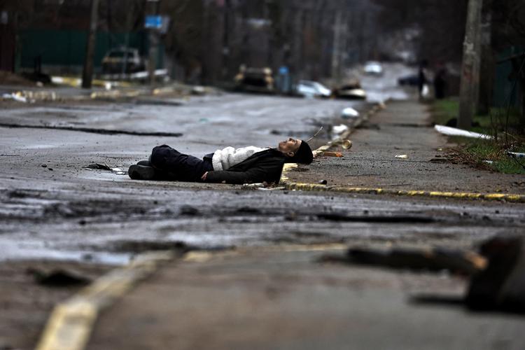 En dræbt civil ligger tilbage på gaden i Butja efter russernes tilbagetrækning fra den ukrainske by. Foto: Zohra Bensemra/Ritzau Scanpix