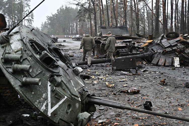 Ukrainske soldater går forbi smadrede russiske kampvogne og militærkøretøjer o Dmytrivka vest for Kyiv.  Efter russerne har trukket sig tilbage fra området. Foto: Genya Savilov/Ritzau Scanpix