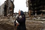 En kvinde bringer sin kat i sikkerhed ud for delvist sammenstyrtede boligblokke i Borodyanka. Foto: Zohra Bensemra/Ritzau Scanpix
