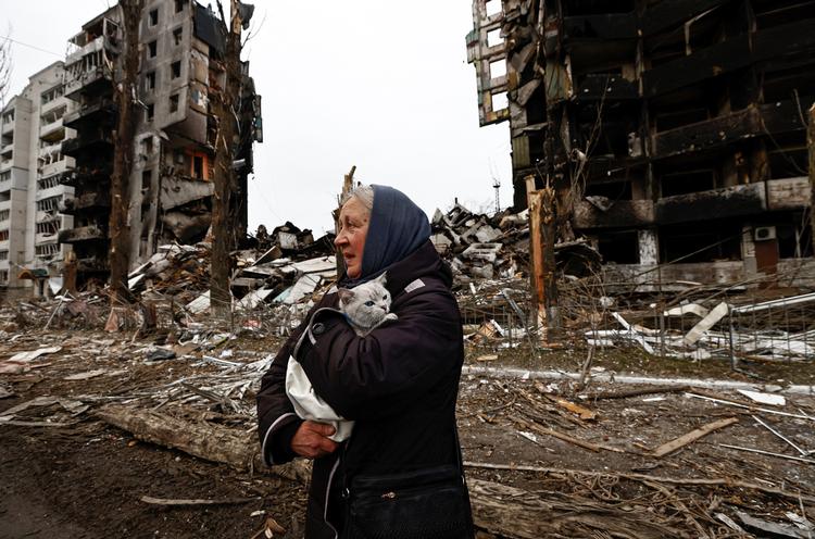 En kvinde bringer sin kat i sikkerhed ud for delvist sammenstyrtede boligblokke i Borodyanka. Foto: Zohra Bensemra/Ritzau Scanpix