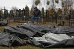 Døde civile samles sammen i sort plastik i byen Butja tæt på hovedstaden Kyiv.     Foto: Stringer/Ritzau Scanpix