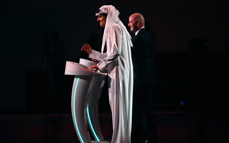 Qatar's emir Tamim bin Hamad al-Thani på scenen sammen med Fifas præsident, Gianni Infantino, under lodtrækningen til VM i Qatar. Det har mødt stærk kritik, at slutrunden skal finde sted i netop Qatar.    Foto: Gabriel Bouys/Ritzau Scanpix