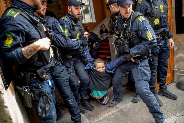 En aktivist er trængt ind til klimatopmødet i Moltkes Palæ og bæres ud igen. Det var Extinction Rebellion, der organiserede protesten. Foto: Jacob Ehrbahn