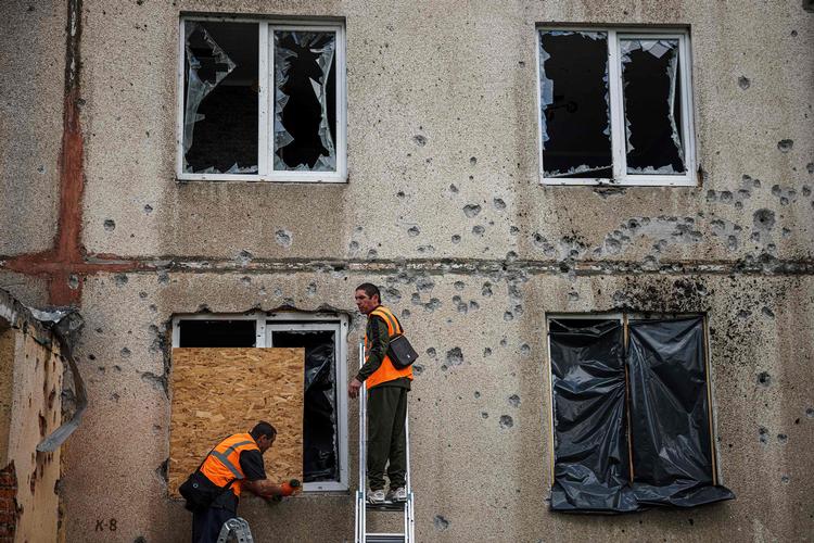 Arbejdere er i gang med at reparere et vindue i en beboelsesejendom i byen Kharkiv, som er Ukraines næststørste by.  Foto: Dimitar Dilkoff/Ritzau Scanpix