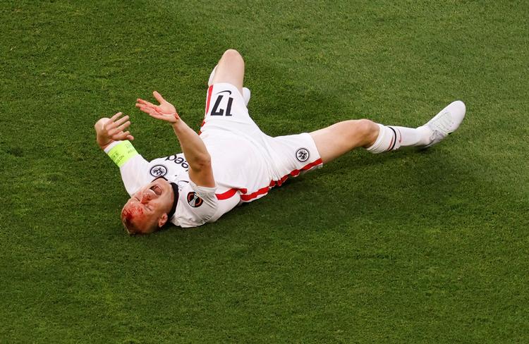 Sebastian Rode gik i græsset efter en høj modstander-støvle og måtte længe modtage behandling på banen.  Foto: Marcelo Del Pozo/Ritzau Scanpix