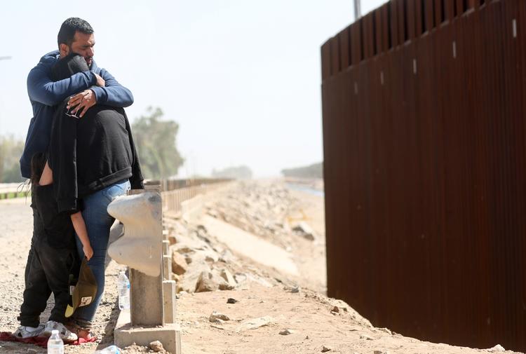 YUMA, ARIZONA- MAY 20: An immigrant mother from Colombia embraces her husband and daughter after traveling for 20 days and crossing through a gap in the U.S.-Mexico border barrier on May 20, 2022 in Yuma, Arizona. Title 42, the controversial pandemic-era border policy enacted by former President Trump, which cites COVID-19 as the reason to rapidly expel asylum seekers at the U.S. border, was set to officially expire on May 23rd. A federal judge in Louisiana delivered a ruling today blocking the Biden administration from lifting Title 42. Mario Tama/Getty Images/AFP == FOR NEWSPAPERS, INTERNET, TELCOS &amp; TELEVISION USE ONLY == Foto: Mario Tama/Ritzau Scanpix