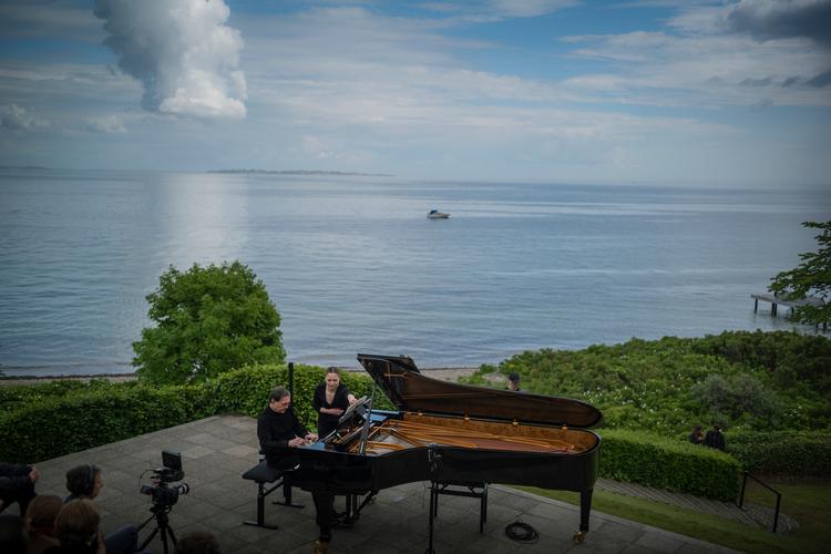 Pierre-Laurent Aimard fik hjælp fra en nodevender under sin koncert på Louisianas terrasse ud mod Øresund. Foto: Carsten Snejbjerg