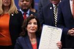 NEW YORK, NEW YORK - JUNE 06: Gov. Kathy Hochul holds up signed legislation as she is surrounded by lawmakers during a bill signing ceremony at the Northeast Bronx YMCA on June 06, 2022 in New York City. Gov. Hochul signed a series of gun reform bills, that will strengthen already strict gun laws in the state. Passed by lawmakers last week, one restriction includes banning anyone under age 21 from buying or possessing a semi-automatic rifle, among a series of other changes. The bills were passed in the wake of two recent mass shootings where an 18-year-old man fatally shot 10 people and injured 3 in Buffalo, New York and just 10 days later an 18-year old man shot and killed 19 children and 2 adults at an elementary school in Uvalde, Texas. Michael M. Santiago/Getty Images/AFP == FOR NEWSPAPERS, INTERNET, TELCOS &amp; TELEVISION USE ONLY == Foto: Michael M. Santiago/Ritzau Scanpix