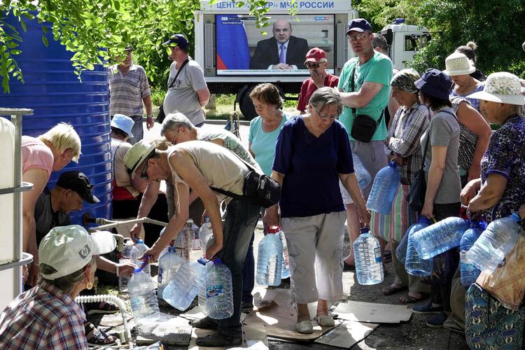 Ukrainere i Mariupol henter rent drikkevand ved en af byens vandposter. Der er blevet indført karantæne i den besatte by efter frygt for koleraudbrud. Foto: Stringer/Ritzau Scanpix