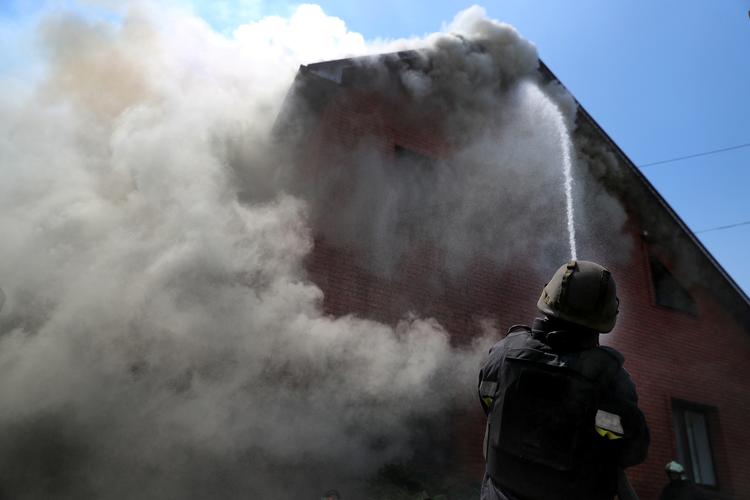 En brandmand prøver at slå flammerne ned efter et russisk angreb på en bygning i Kharkiv. Foto: Ivan Alvarado/Ritzau Scanpix
