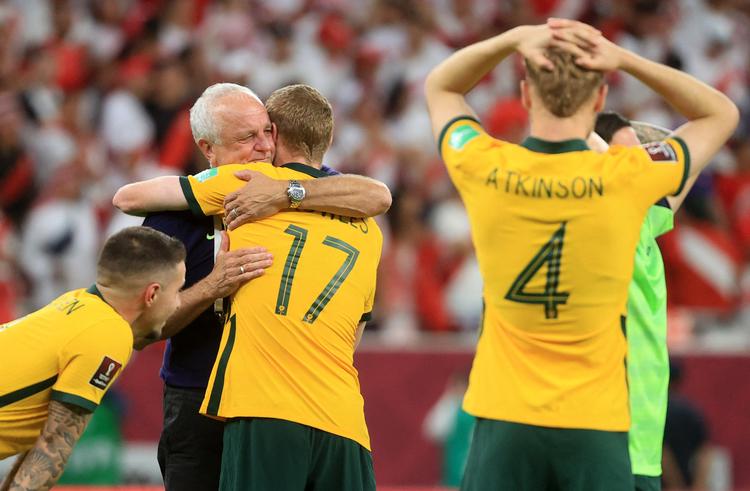 Den australske landstræner, Graham Arnold, omfavner sine spillere efter den dramatiske afslutning mod Peru i kvalifikationsturneringen, der fandt sted i Qatar. Den kommende og stærkt omstridte VM-vært. Foto: Mohammed Dabbous/Ritzau Scanpix