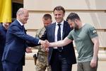 Ukraines præsident, Volodymyr Zelensky, hilser på Tysklands kansler, Olaf Scholz, mens Frankrigs præsident, Emmanuel Macron, kigger på.  Foto: Ludovic Marin/Ritzau Scanpix