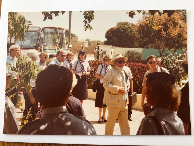 Simon Spies ankommer til et fire timer langt frokostbesøg i Gambia med stort følge bestående af direktion, presse og morgenbolledamer. Eva Vedel ses i baggrunden bag guiden med hat. Foto: Privat