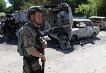  En ukrainsk soldat i Lysytjansk passerer et par bilvrag.  Foto: Anatolii Stepanov/Ritzau Scanpix