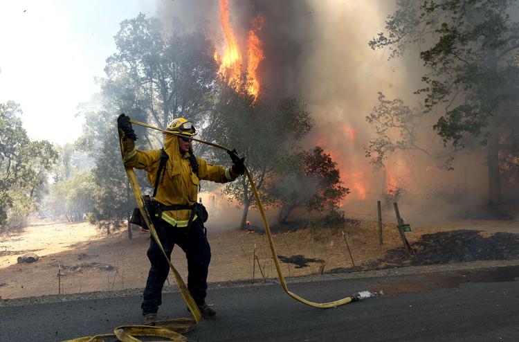 MARIPOSA, CALIFORNIA - JULY 23: A Cal Fire firefighter pulls hose as he battles the Oak Fire on July 23, 2022 near Mariposa, California. The fast moving Oak Fire burning outside of Yosemite National Park has forced evacuations, charred over 4500 acres and has destroyed several homes since starting on Friday afternoon. Justin Sullivan/Getty Images/AFP == FOR NEWSPAPERS, INTERNET, TELCOS &amp; TELEVISION USE ONLY == Foto: Justin Sullivan/Ritzau Scanpix