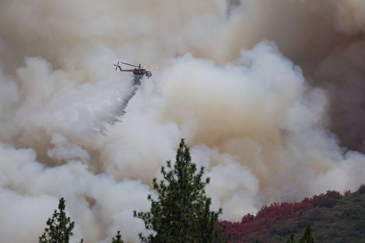 JERSEYDALE, CALIFORNIA - JULY 24: A firefighting helicopter drops water on the Oak Fire as it burns through the area on July 24, 2022 near Jerseydale, California. The fast moving Oak Fire burning outside of Yosemite National Park has forced evacuations, charred over 14, 000 acres and has destroyed several homes since starting on Friday afternoon. The fire is zero percent contained. Justin Sullivan/Getty Images/AFP == FOR NEWSPAPERS, INTERNET, TELCOS &amp; TELEVISION USE ONLY == Foto: Justin Sullivan/Ritzau Scanpix