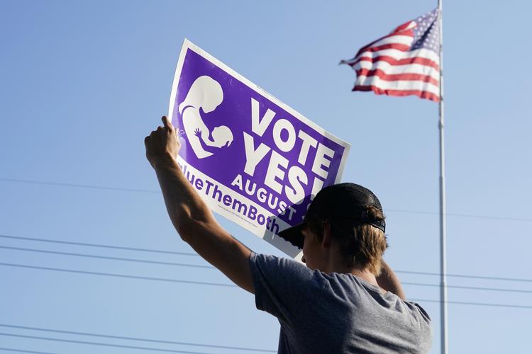Olathe, KANSAS - AUGUST 01: A supporter of the Vote Yes to a Constitutional Amendment on Abortion holds up a sign along 135th Street on August 01, 2022 in Olathe, Kansas. On August 2, voters will vote on whether or not to remove protection for abortion from the state constitution. Kyle Rivas/Getty Images/AFP == FOR NEWSPAPERS, INTERNET, TELCOS &amp; TELEVISION USE ONLY == Foto: Kyle Rivas/Ritzau Scanpix