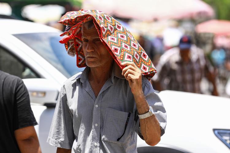 Når temperaturen i skyggen ligger over 50 grader som her i Irak, så gælder alle kneb for at beskytte sig mod solen.  Foto: Ameer Al-mohammedawi/Ritzau Scanpix