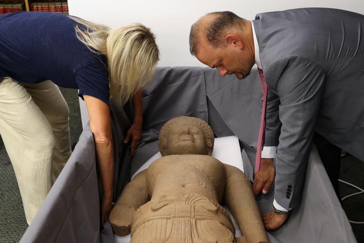 Hinduistisk Yaksha-figur af sandsten fra det 10. århundrede bliver forberedt til ceremonien, hvor en række cambodianske kunstskatte skulle overdrages fra de amerikanske til de cambodianske myndigheder. Foto: Andrew Kelly/Ritzau Scanpix