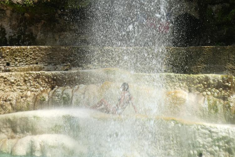 Støvregnen fra vandfaldet og luften går næsten i ét med hinanden i sommerens varme. Det er 38 grader – kun lidt koldere end vandet. Men om vinteren kan det blive ned til 15 grader, og så kan man varme sig i kilderne. Foto: Stine Kærgaard Nissen