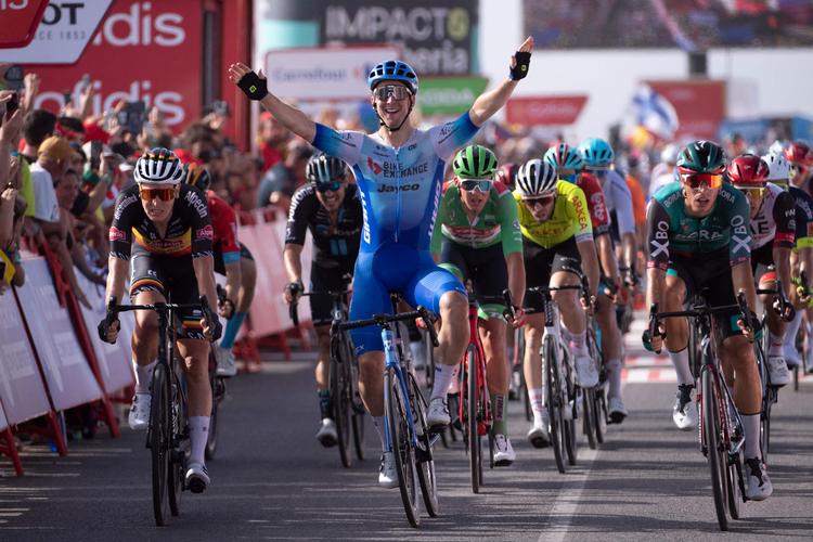 Australieren Kaden Groves jubler over sejren på 11. etape i Vuelta a España, mens Mads Pedersen, der ses under vinderens venstre arm, suser over stregen som nr. 5.
 Foto: Jorge Guerrero/Ritzau Scanpix
