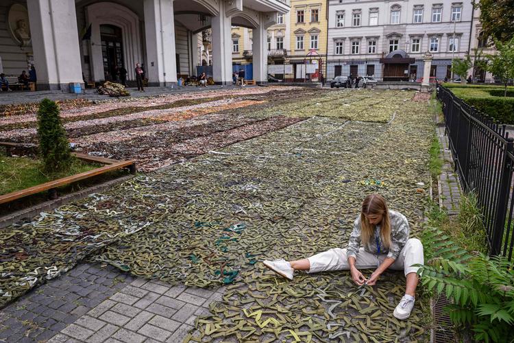 Alle dele af det ukrainske samfund bidrager til forsvaret mod den russiske besættelsesmagt. Her er en kvinde ved at lave kamuflagenet til Ukraines hær. Foto: Yuriy Dyachyshyn/Ritzau Scanpix
